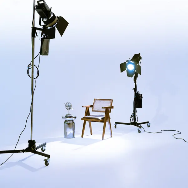 The madd. studio: two film lights aimed at a wooden chair on a white background
